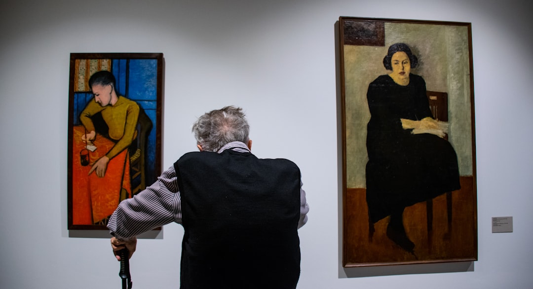 man looking at painting galleries