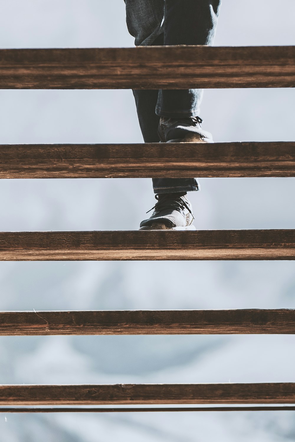 person stepping on wooden stair