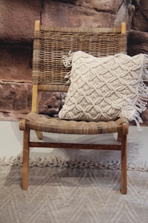Soft cream fabric draped over a wooden chair with a sprig of eucalyptus resting on it