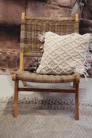 A finished heirloom pillow signed with a heartfelt message, resting on a worn leather chair.