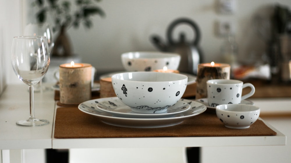 white and black ceramic wares on table