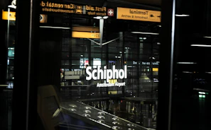 Friendly driver greeting passengers at Schiphol Airport terminal