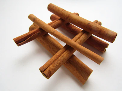 Elegant packaging of premium cinnamon sticks arranged on a minimalist beige surface.