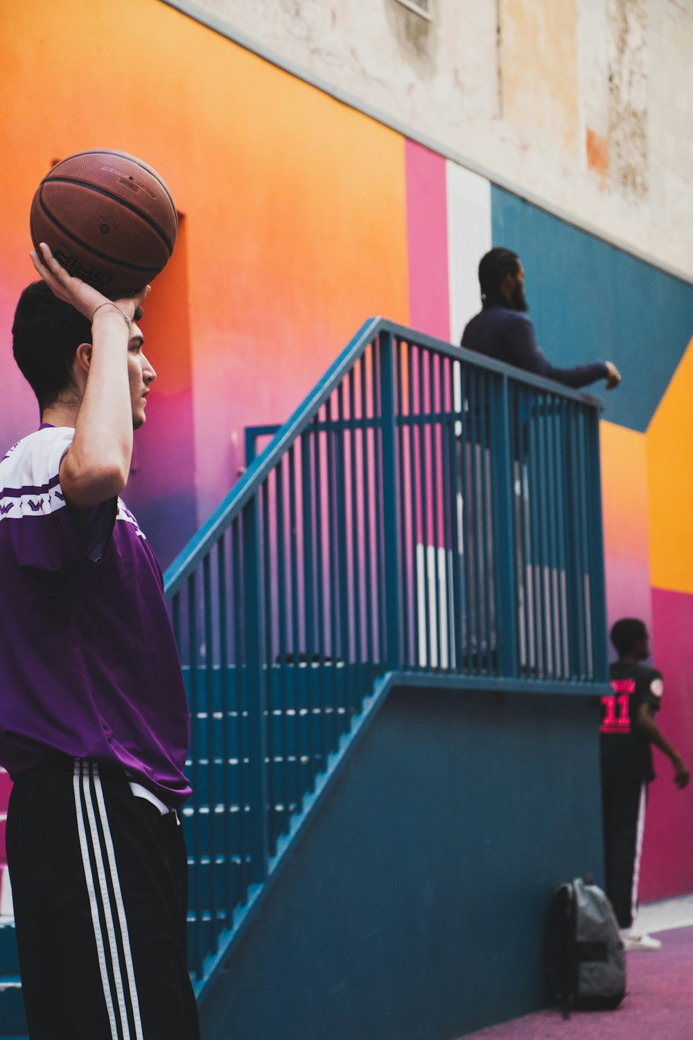 Un giovane che tiene un pallone da basket in faccia