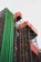 A building facade featuring an industrial design with prominent colorful pipes. Green cylindrical pipes run vertically alongside red cuboid structures, all supported by a complex network of metallic framing. The structure's design is modern and unconventional, suggesting a blend of functionality and artistic expression.