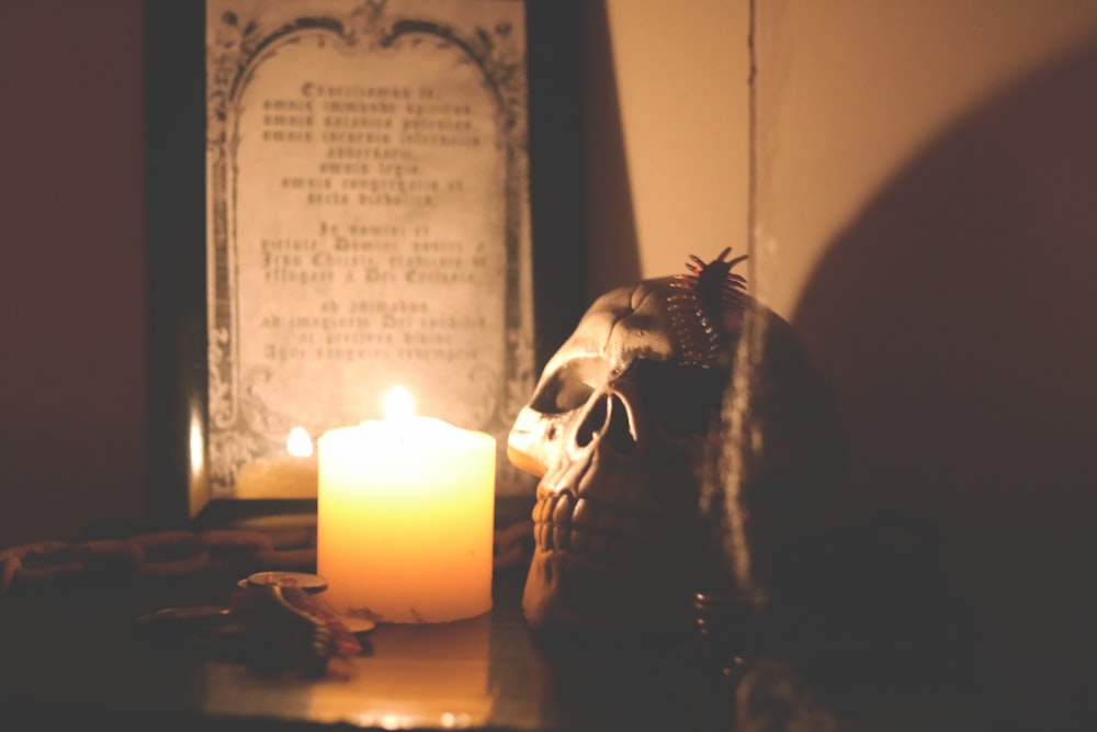 lighted candle beside skull