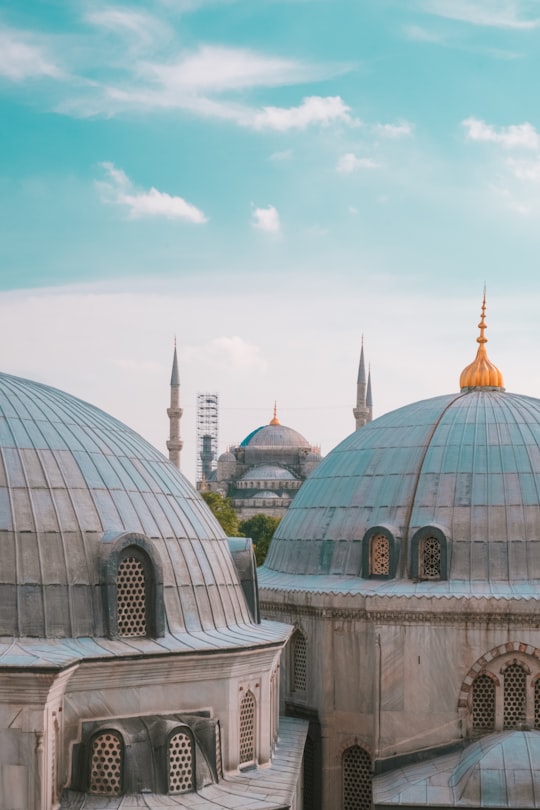 blue domed mosque through mosques during daytime in Hagia Sophia Museum Turkey