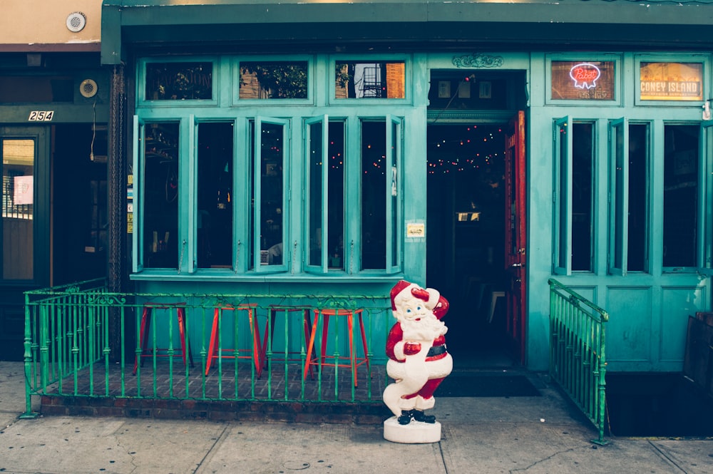 Santa Claus statuette standing outside beside the door