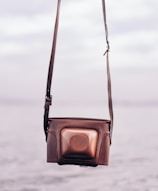 A casual crossbody bag resting on a city bench with blurred urban background.