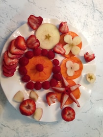 Close-up of beautifully sliced fresh fruits arranged on a wooden platter.