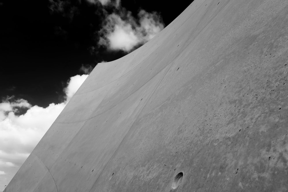 Un homme sur une planche à roulettes sur le côté d’un mur de ciment