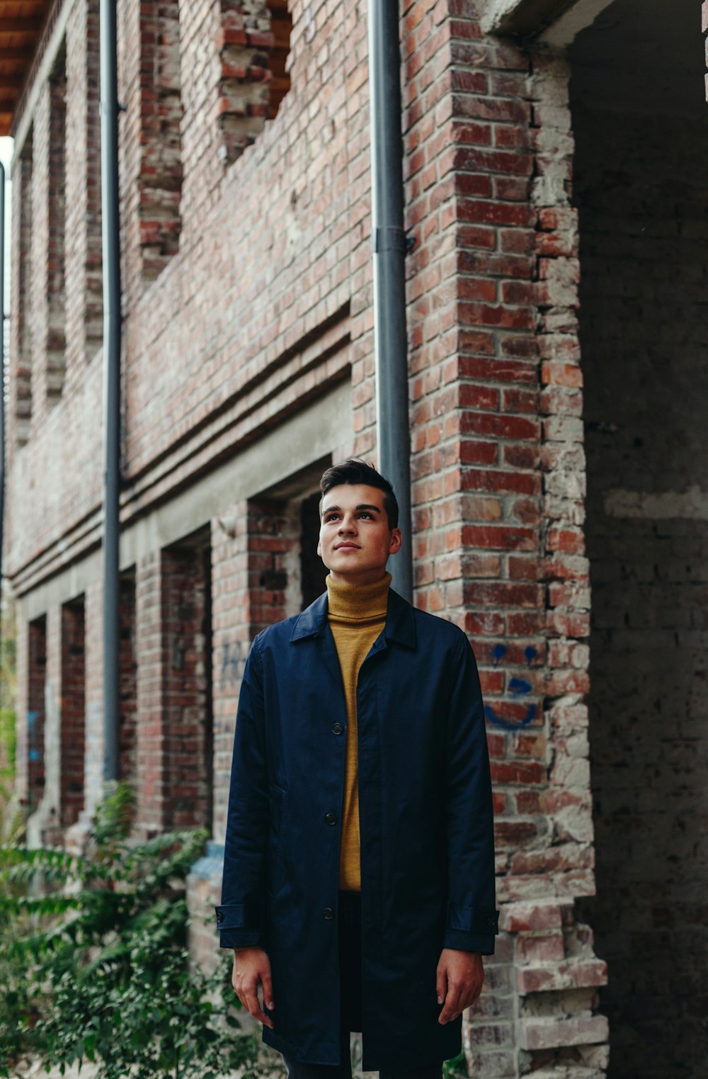 man standing on front of brown concrete building