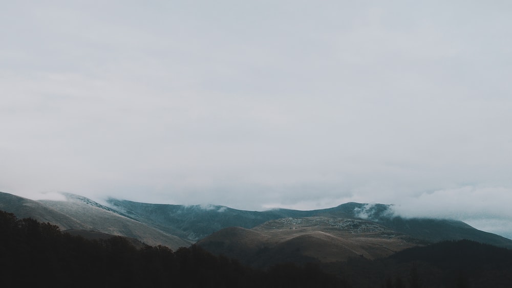 brown mountain under grey clouds