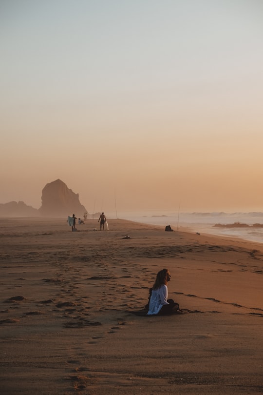 woman siting on shore in Santa Cruz Portugal