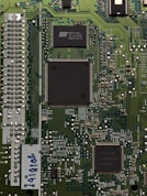 three black IC's attached on green PCB board