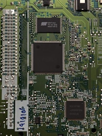 three black IC's attached on green PCB board