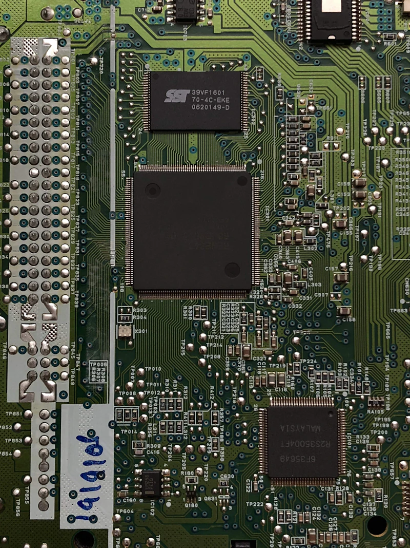 Three black ICs on a green PCB