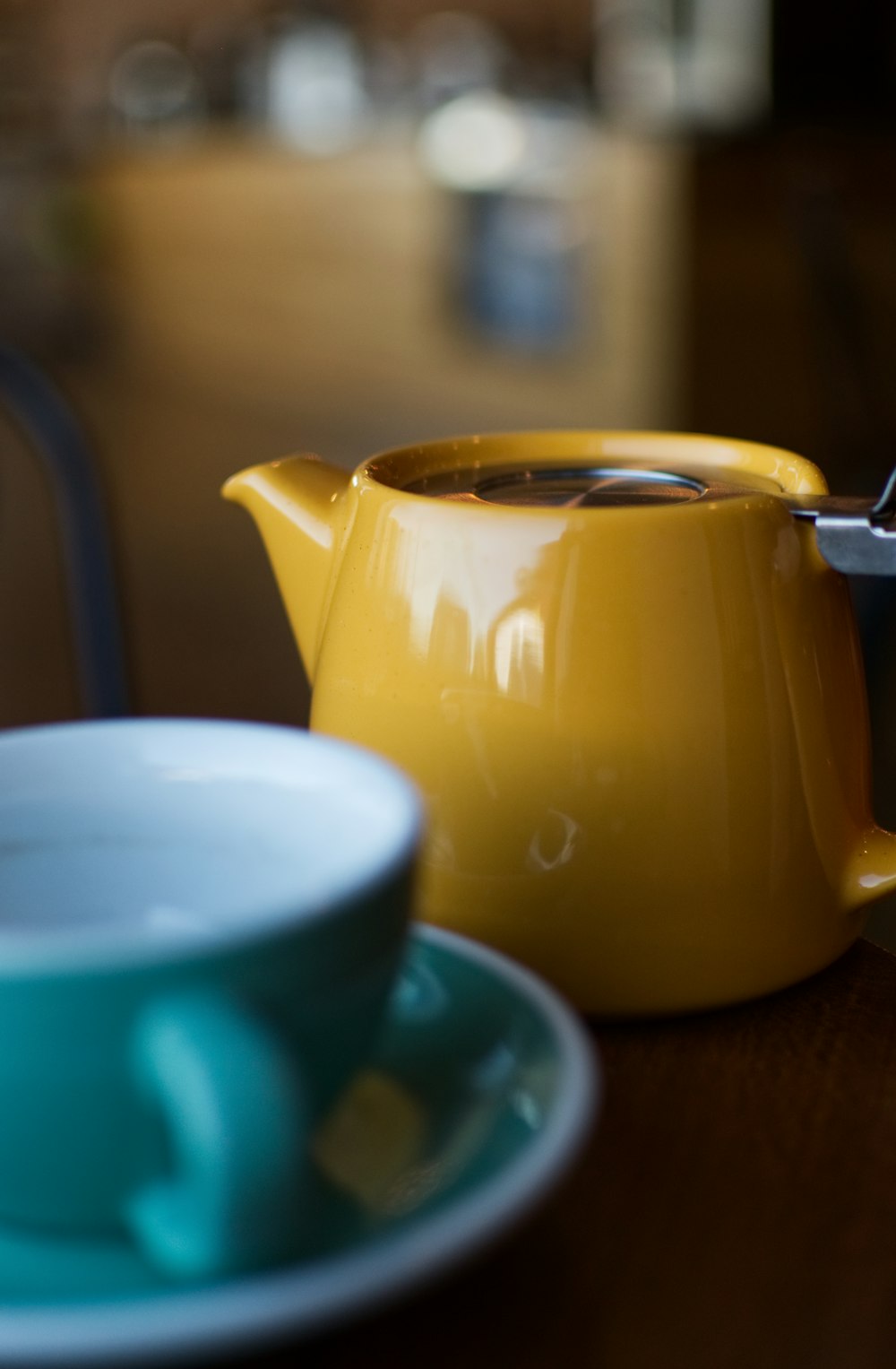 shallow focus photography of yellow ceramic teapot