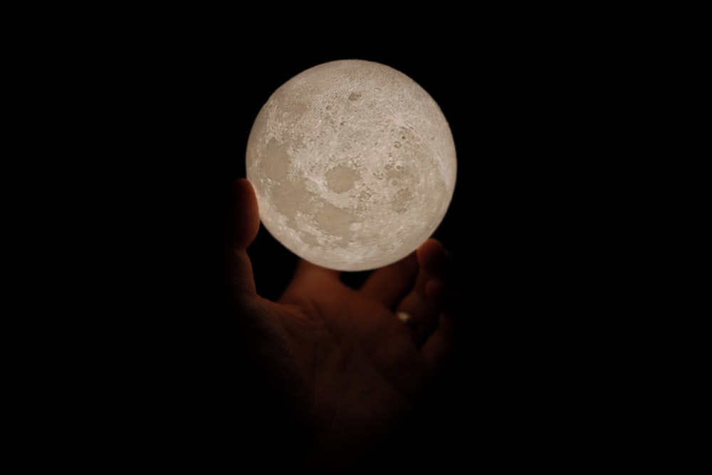 person holding white moon lamp