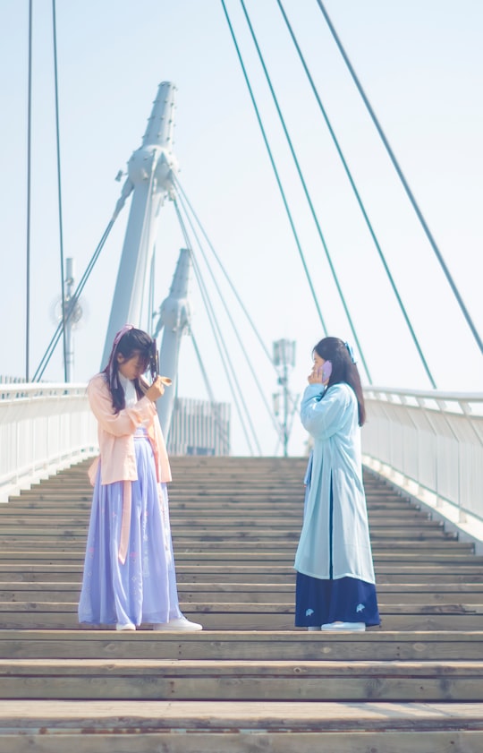 two woman standing on concrete stairs during daytime in Zhengzhou China