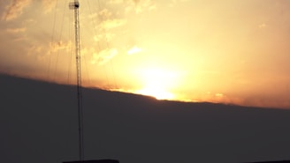 A radio tower against a sunset sky, symbolizing strong broadcast signals across Waqooyi Bar.