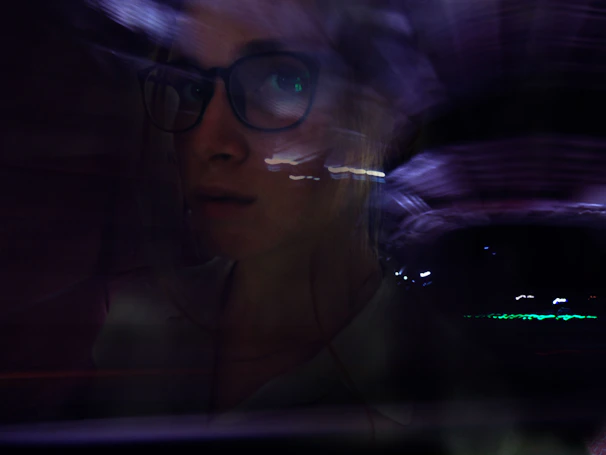 Monochrome portrait of PHNK surrounded by soft blur and glassmorphic UI elements.