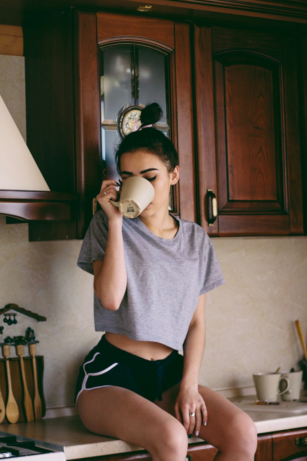 woman sitting on kitchen area under wooden kitchen cupboard