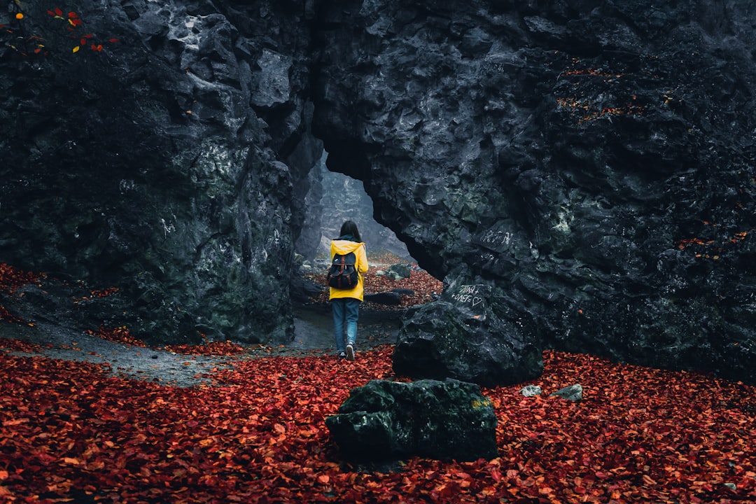 woman walking towards rock formation,