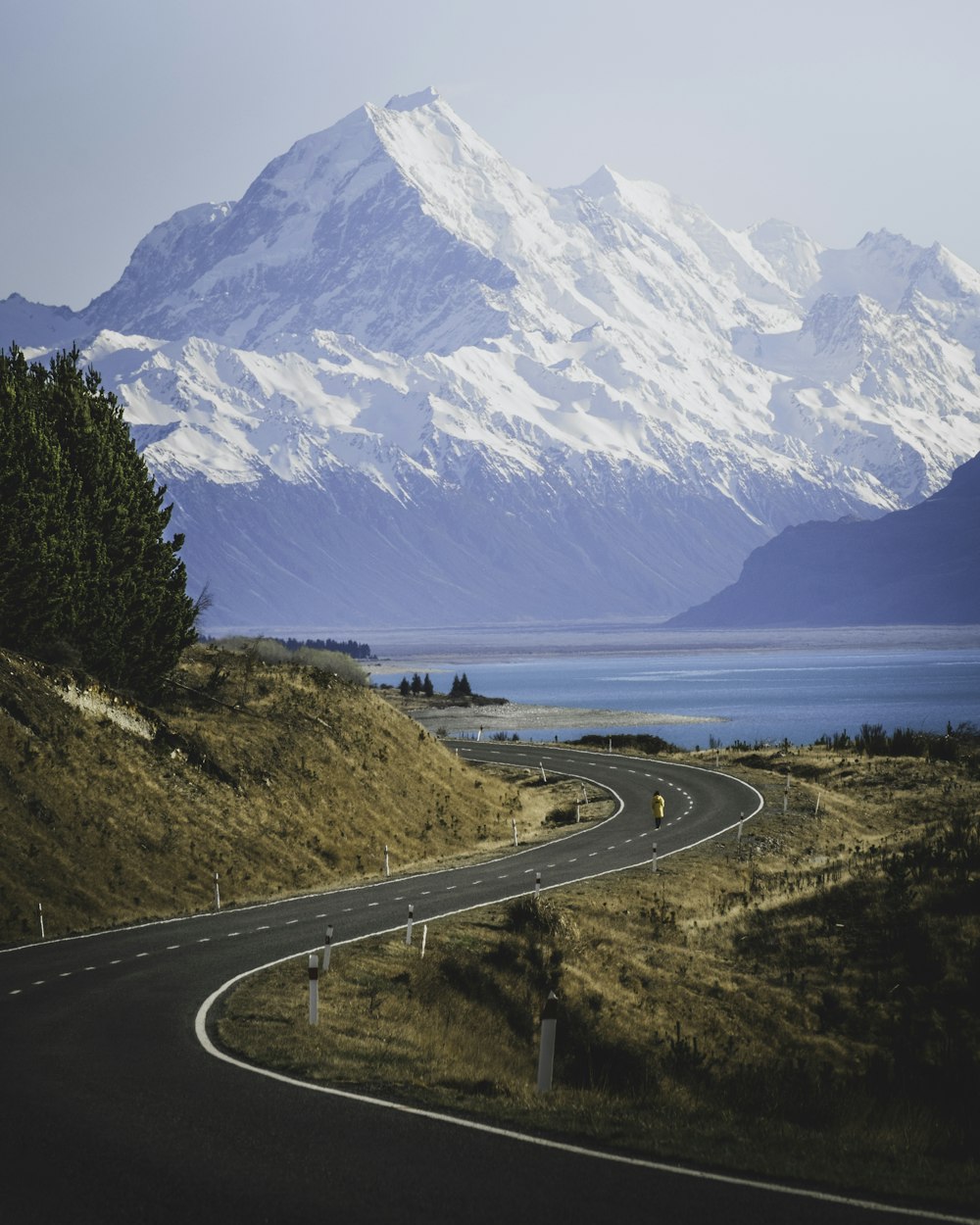 body of water near road and mountain