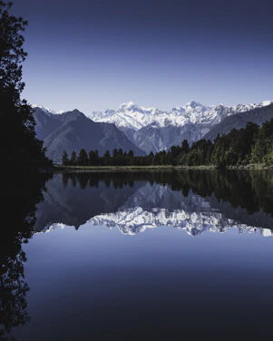 Tranquil lake surrounded by snowy mountains, reflecting vision-driven lifestyle