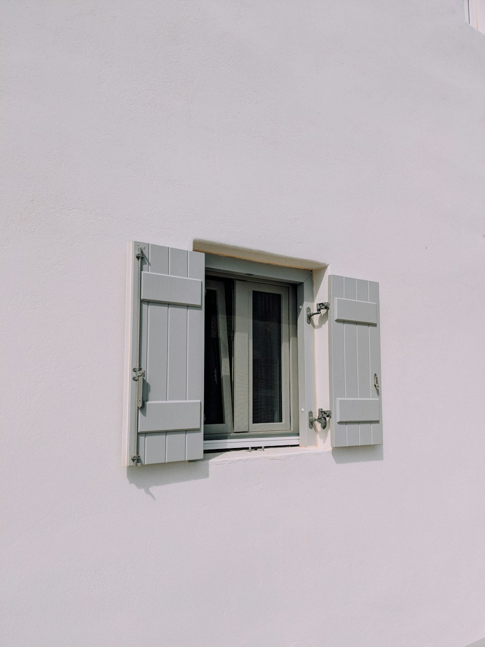 gray wooden casement window panel in white concrete building