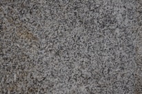 Close-up of polished granite countertop with natural light highlighting its texture.