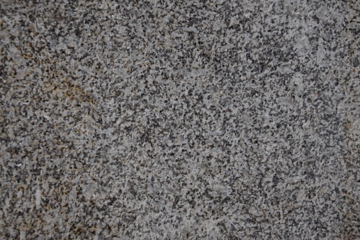 Close-up of a polished quartz countertop with natural light highlighting its texture.