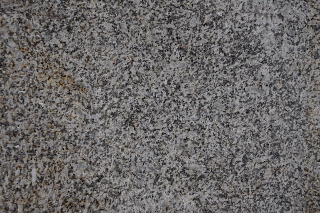 Close-up of a granite fabricator applying epoxy adhesive on a stone slab