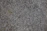 Close-up of polished granite countertop with natural veining under soft kitchen lighting.