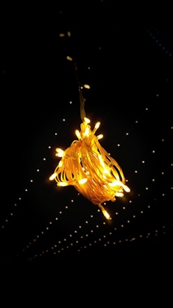 A softly glowing outdoor event illuminated with warm fairy lights and golden LED accents.