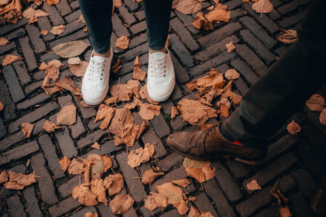 two person on floor with fall leaves