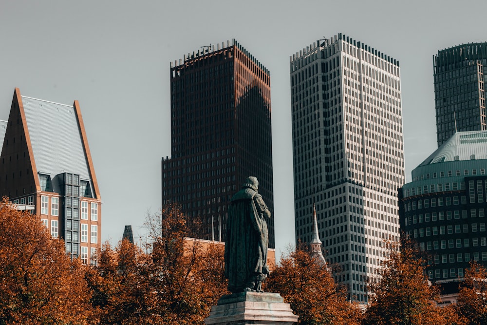 statua di cemento vicino agli edifici della città durante il giorno