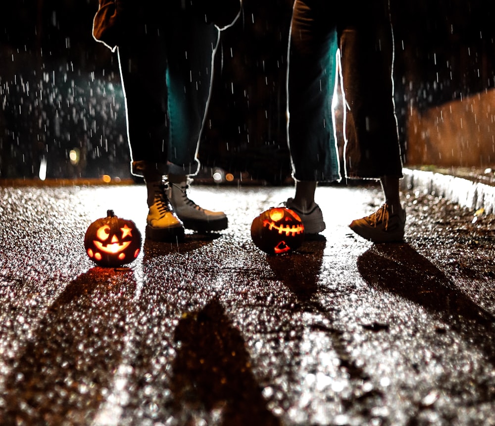 two people standing near Jack-O Lanterns