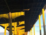 Close-up of a bridge's intricate support cables and beams illuminated by soft sunlight.
