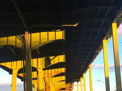 Close-up of a bridge's intricate support cables and beams illuminated by soft sunlight.