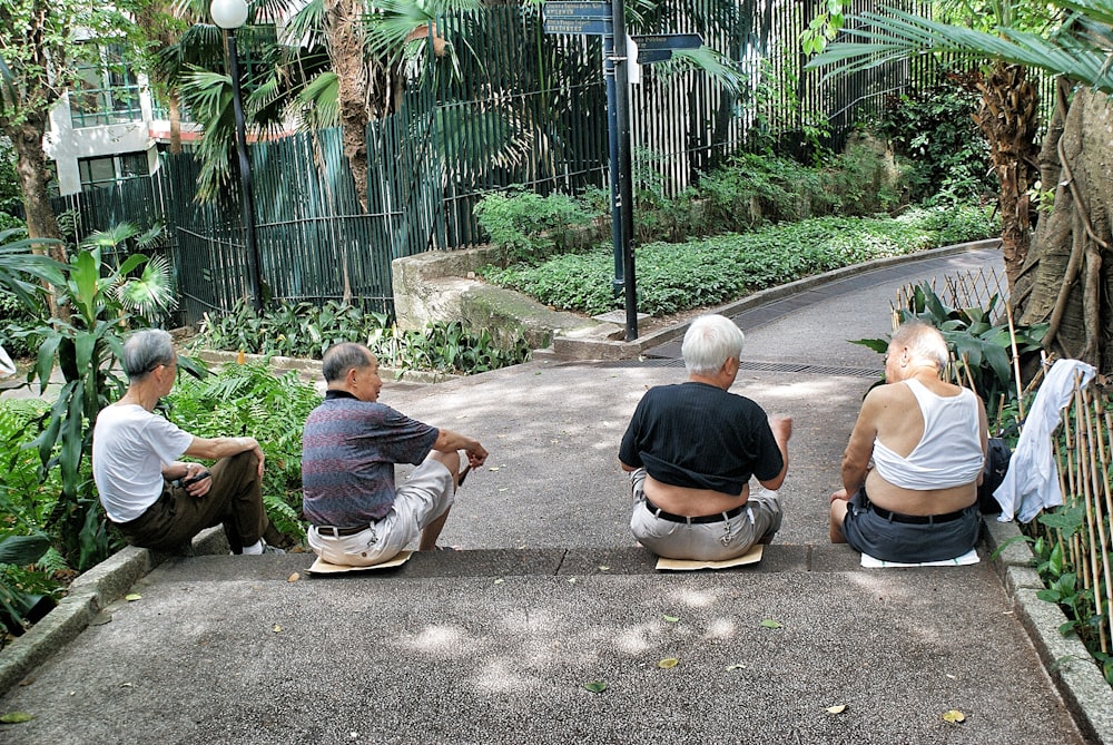 four persons sitting on gray surface