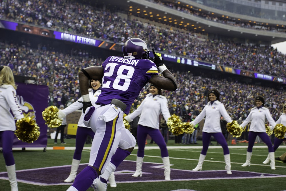 purple and white Peterson 28 running on stadium