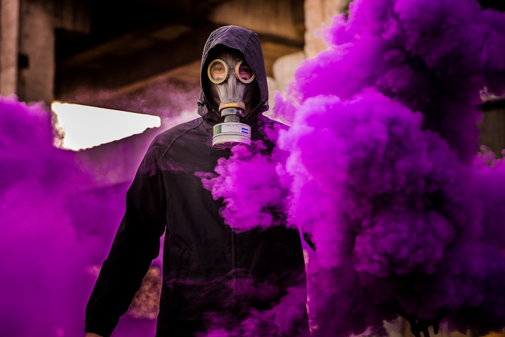 hombre con máscara con fondo de humo púrpura