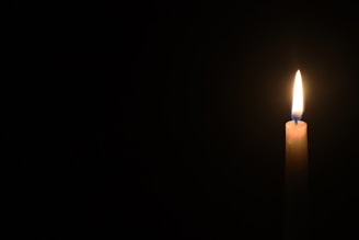 A glowing candle illuminating a dark room.