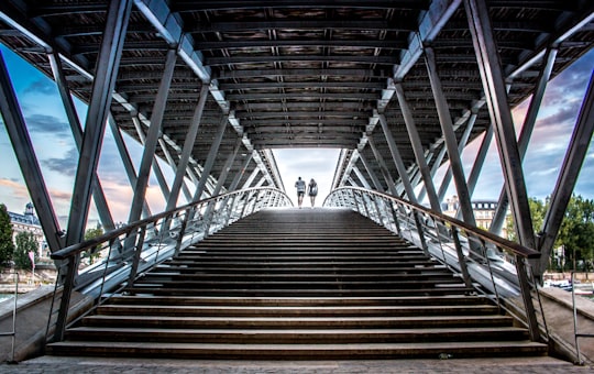 man and woman crossing bridge in Tuileries Garden France