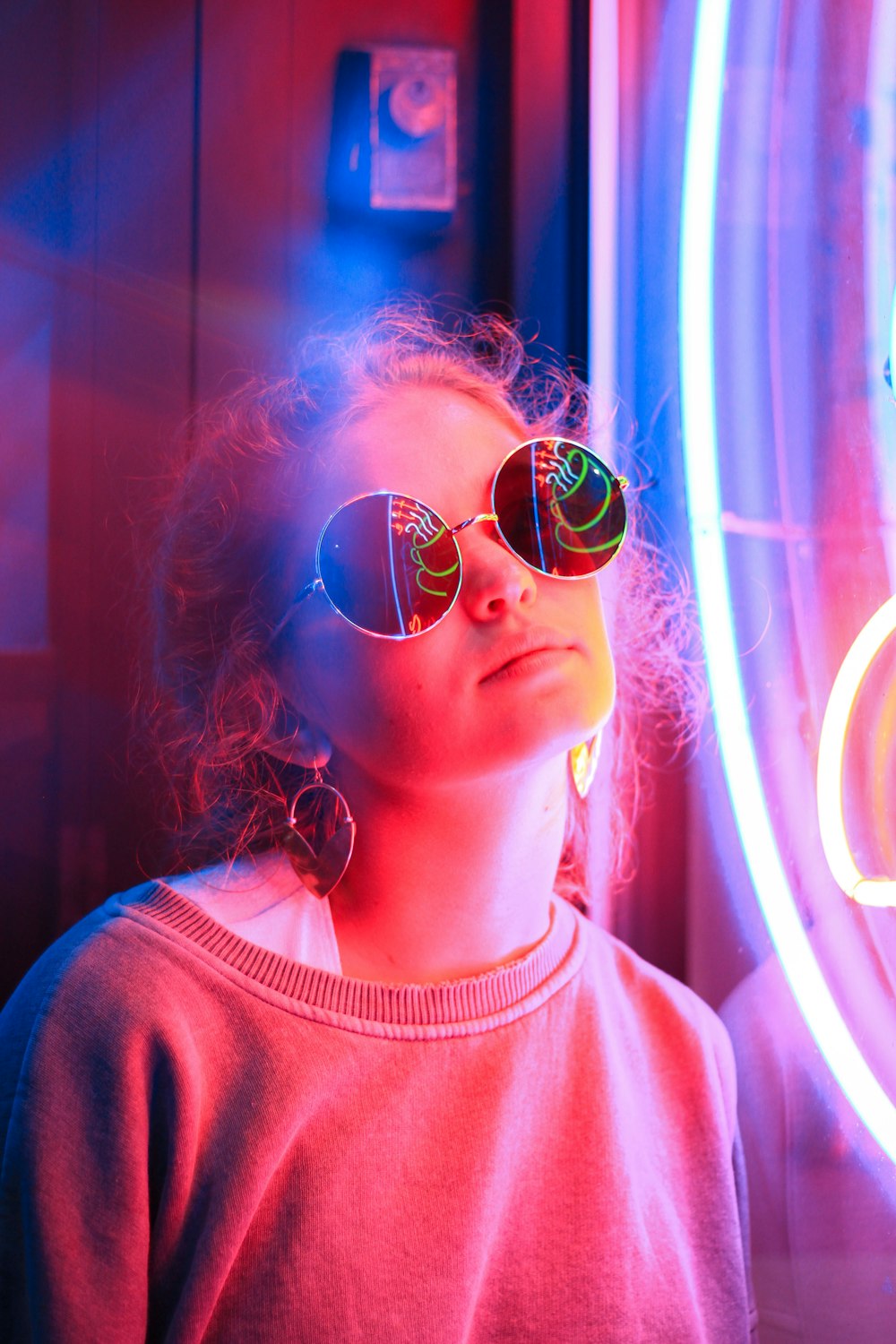 woman standing beside neon signage