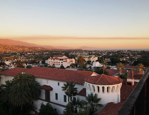 a view of a city with palm trees and mountains in the background