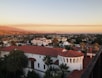 a view of a city with palm trees and mountains in the background
