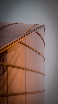 Close-up of a polished metal sheet reflecting modern architectural lights.